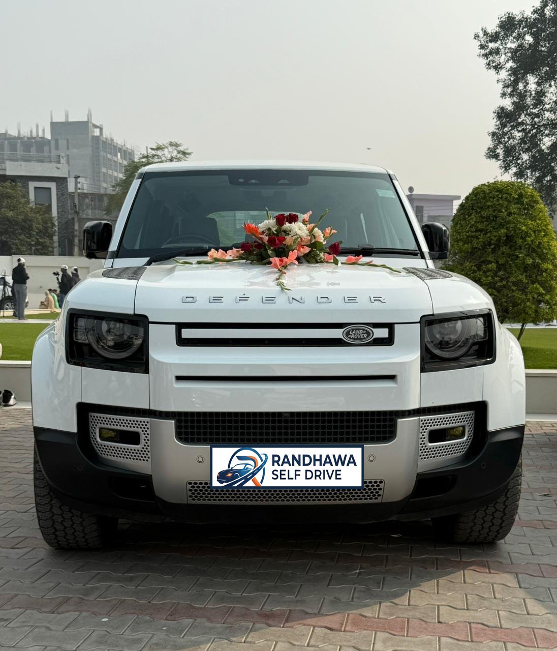White Land Rover Defender with a flower bouquet on the bonnet