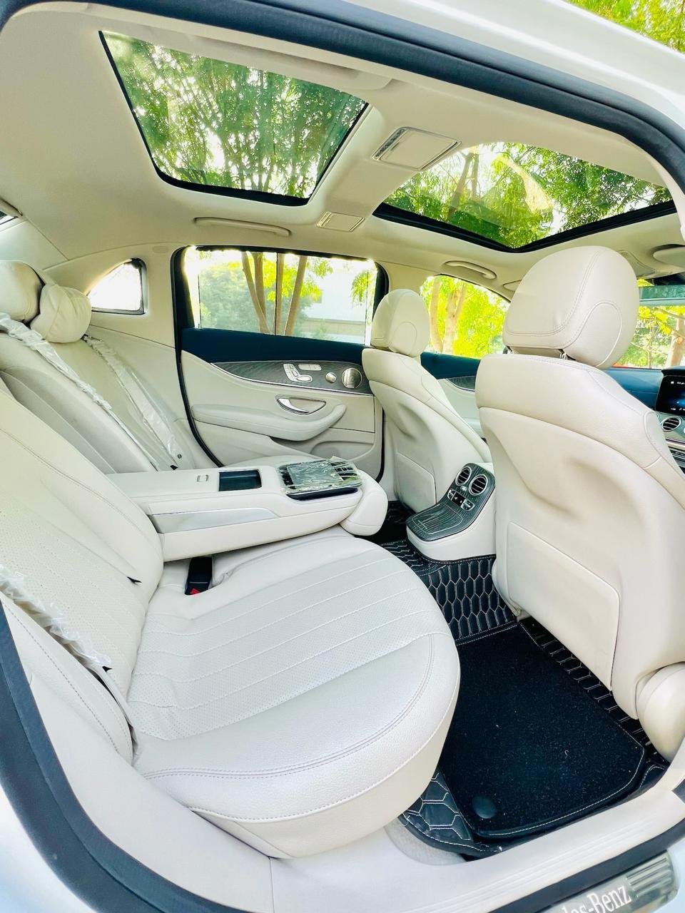 Cream leather rear seat of the Mercedes-Benz E-Class under a panoramic sunroof