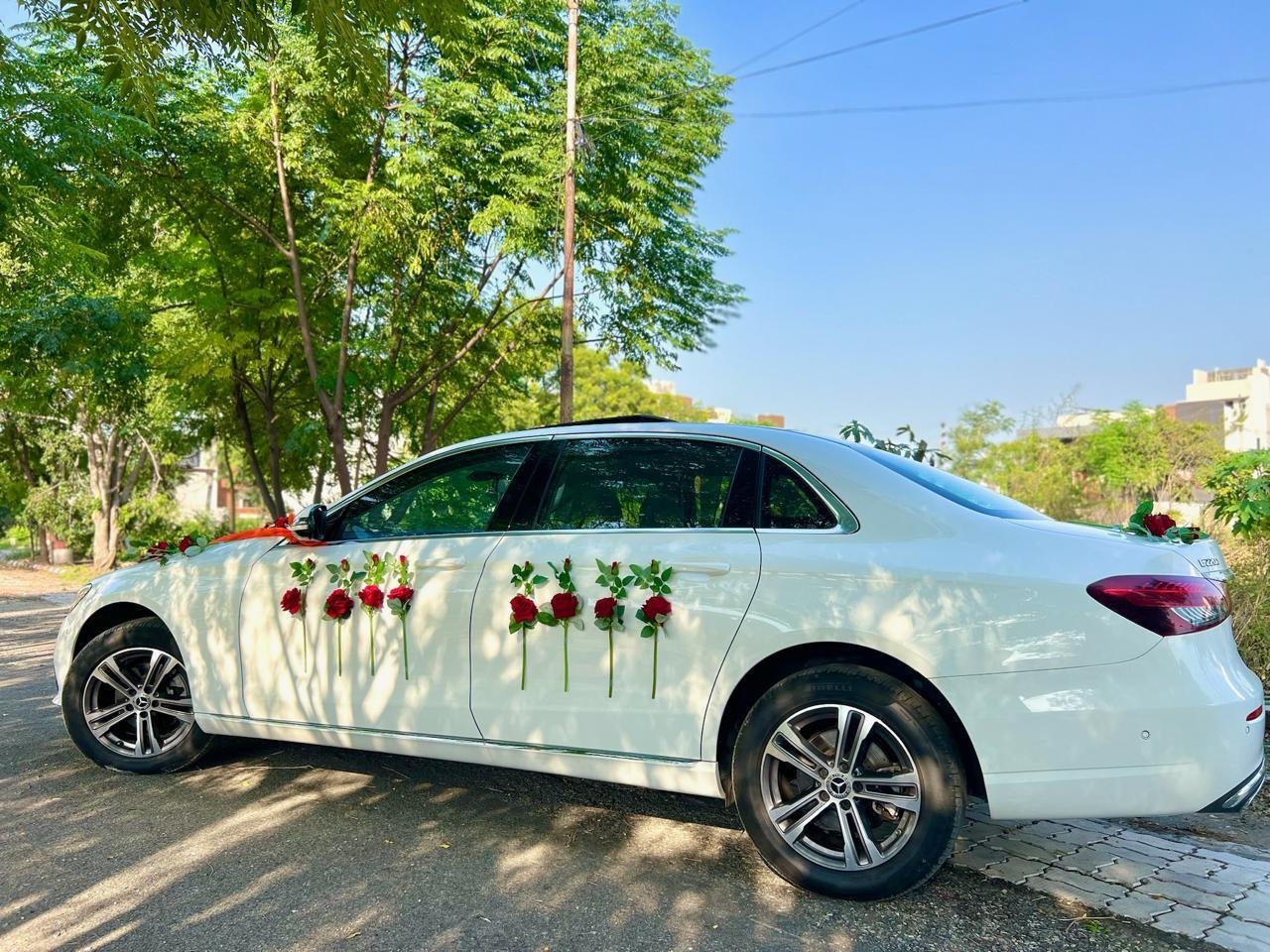 Side view of the white Mercedes-Benz E-Class with red roses on both doors